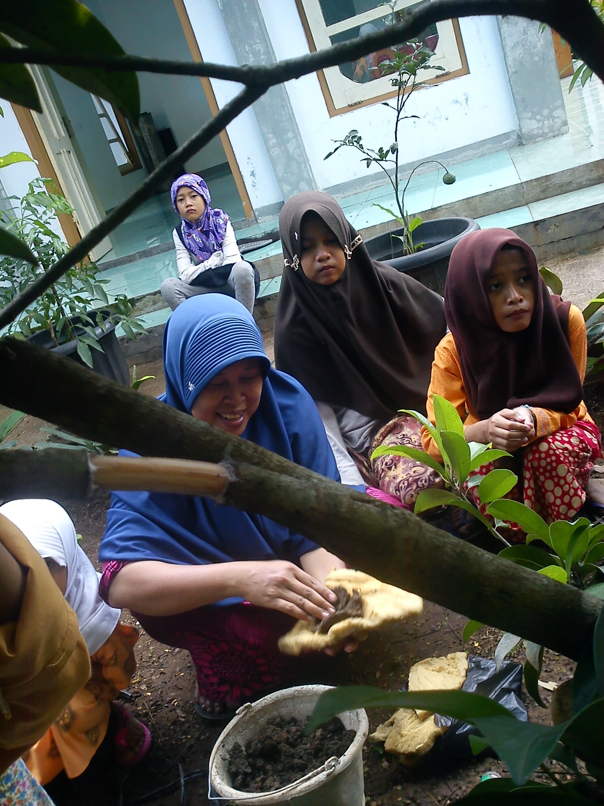 Ibu panti mengajari meletakkan tanah ke gabus atau bisa juga plastik